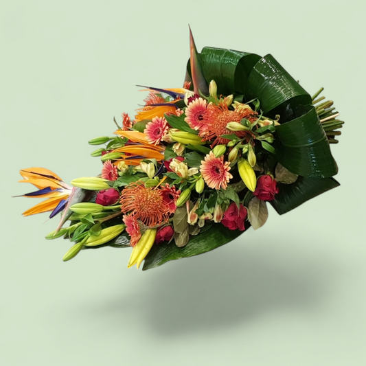 Liggend Rouwboeket met Geel en Oranje Bloemen – Inclusief Strelitzia voor een Warm en Opvallend Eerbetoon