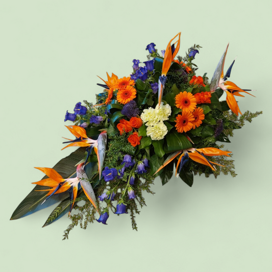 Rouwstuk Druppel met Strelitzia, Gerbera en Delphinium – Een Krachtig en Kleurrijk Eerbetoon